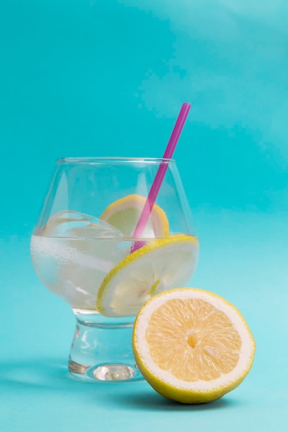 Rinfrescante bicchiere di soda con spicchi di limone e ghiaccio, tutto è nel blu del Mediterraneo e dell'estate