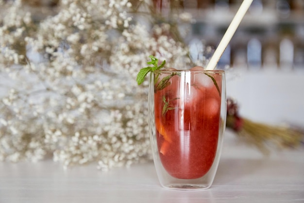 Rinfrescante cocktail mojito alla fragola nel caffè Gypsophila fiori sfondo Spazio di copia