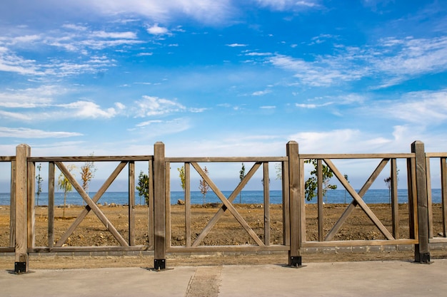 Ringhiera in legno per parco e giardino. Cielo azzurro spazio aperto.