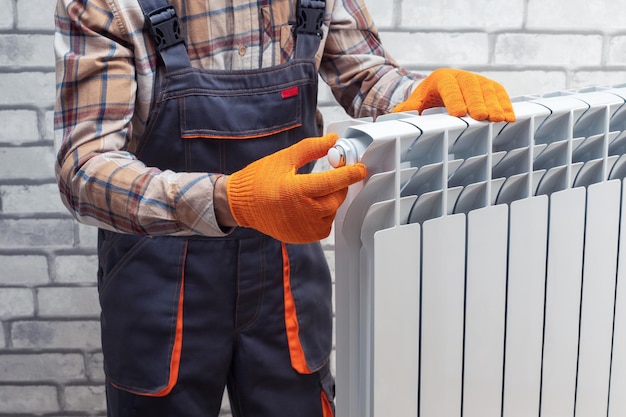 Riparatore che installa il radiatore di riscaldamento a casa ripara il sistema di riscaldamento in appartamento