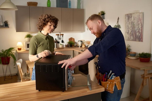 Riparatore che ripara il forno a microonde a casa