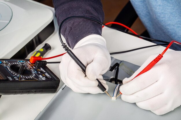 Riparatore che smonta le parti interne di un computer nel centro di assistenza