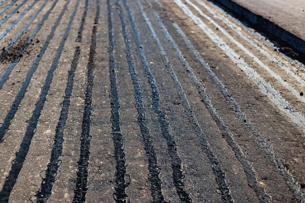 Riparazione della pavimentazione in asfalto della strada Asfalto nuovo sulla strada Bitume caldo durante la posa di asfalto nuovo