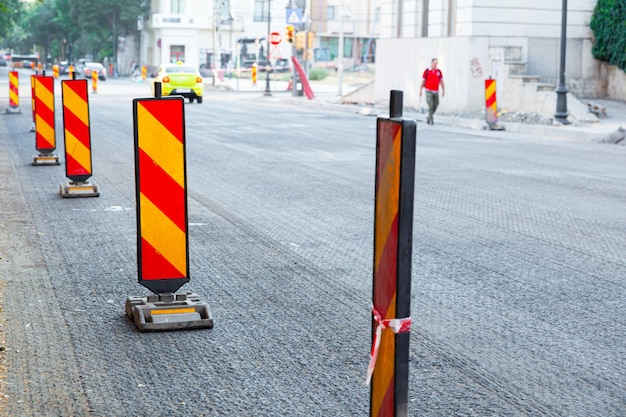 Riparazione della strada asfaltata della città Sostituzione dell'asfalto e della recinzione con segnali stradali