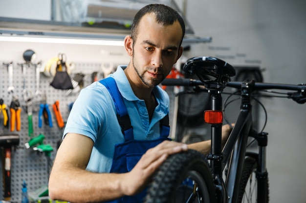 Riparazione di biciclette in officina, l'uomo controlla le gomme