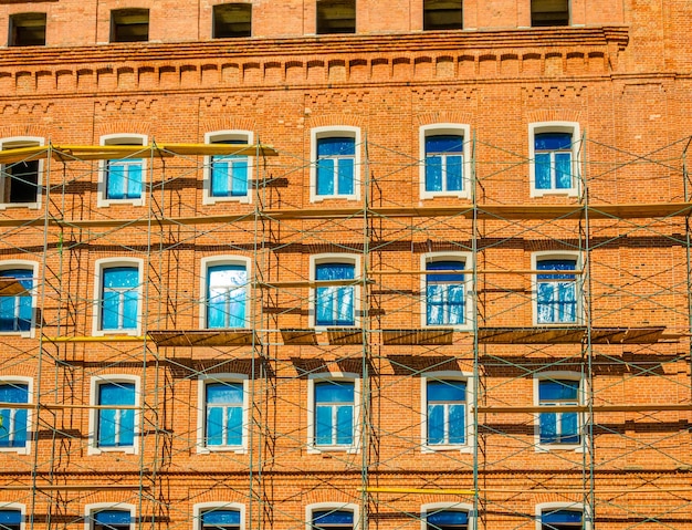 Riparazione di un edificio in mattoni con impalcature.