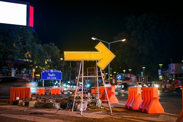 riparazione stradale con segno di freccia gialla di notte