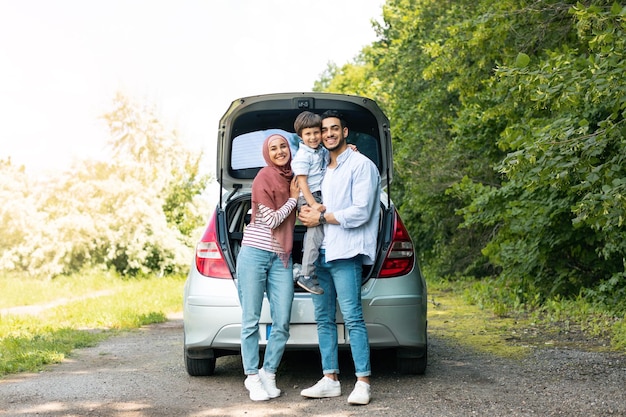 Riposa all'aperto dal viaggio di famiglia su strada in estate Uomo e donna arabi millenari soddisfatti in hijab