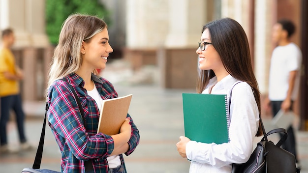 Riposo tra le lezioni ragazze che parlano all'aperto dopo le lezioni riposo nel campus universitario