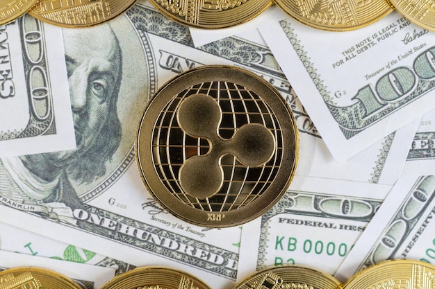 Ripple criptovaluta monete d'oro e dollaro in background