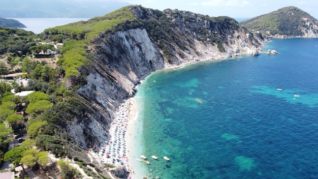 Ripresa aerea del turista con ombrelloni nel Parco Nazionale dell'Arcipelago Toscano, Italia