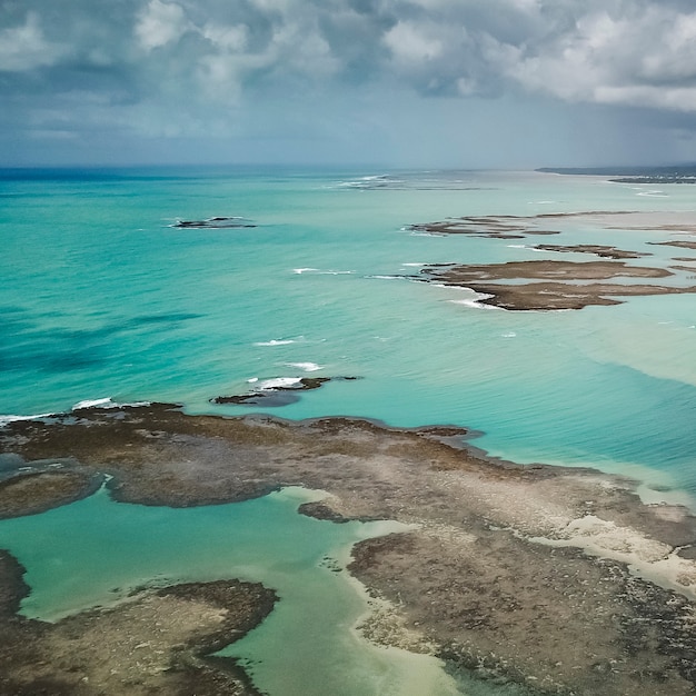 Ripresa aerea dell'oceano turchese brasiliano con un cielo nuvoloso