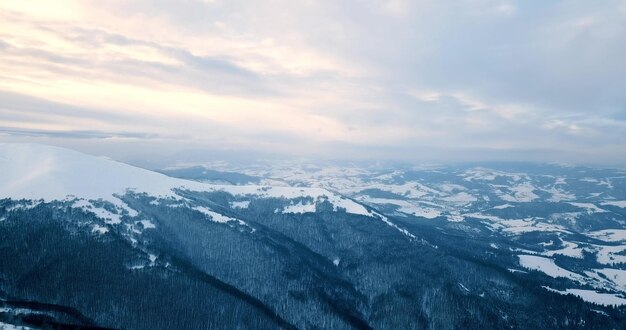 Ripresa aerea della maestosa alba nelle montagne La valle tra le montagne è ricoperta di nebbia ed è illuminata dai caldi raggi del sole nascente Montagne coperte di foresta naturale