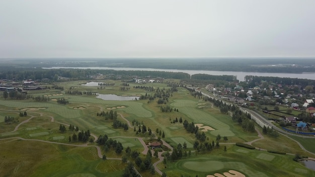 Ripresa aerea di campi da golf e borgata vicino al fiume