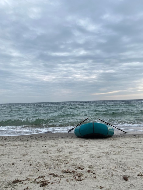 Ripresa verticale di una barca a remi gonfiabile blu sulla sabbia in spiaggia