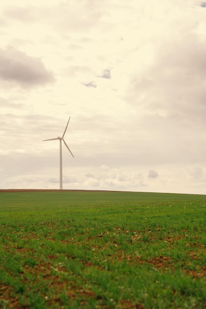 Ripresa verticale di una turbina eolica bianca in primavera in una giornata nuvolosa