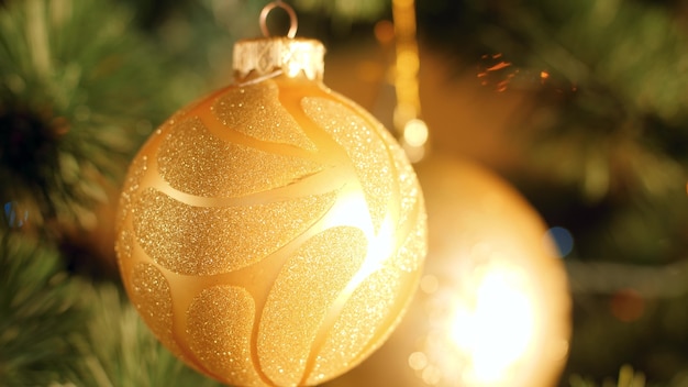 Riprese macro di bellissime palline dorate e luci incandescenti sull'albero di Natale