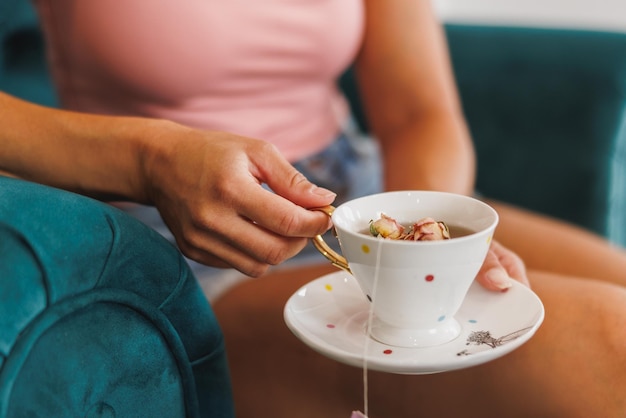 Riprese ritagliate di una donna irriconoscibile che si gode una tazza di tisana durante il trattamento in un salone di bellezza.