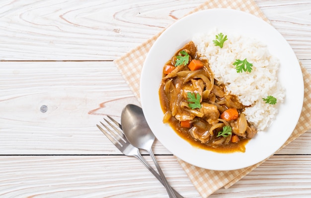 Riso al curry giapponese con fette di maiale, carota e cipolle