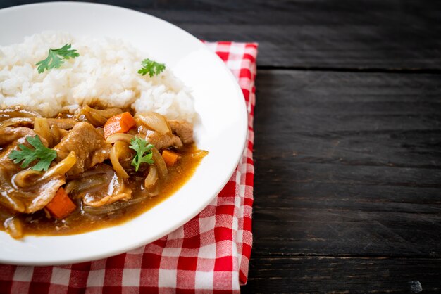 Riso al curry giapponese con fette di maiale, carota e cipolle