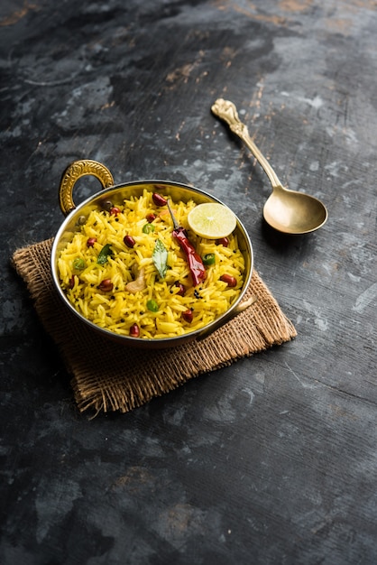 Riso al limone o fodnicha bhat è riso alla curcuma dell'India meridionale o ricetta maharashtriana che utilizza riso avanzato guarnito con foglie di curry di noci e succo di limone, messa a fuoco selettiva