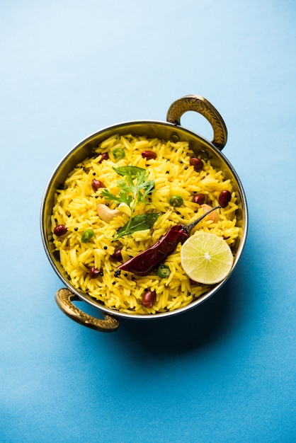 Riso al limone o fodnicha bhat è riso alla curcuma dell'India meridionale o ricetta maharashtriana che utilizza riso avanzato guarnito con foglie di curry di noci e succo di limone, messa a fuoco selettiva