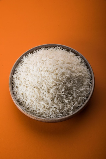 Riso basmati bianco indiano cotto piano in una ciotola di ceramica, fuoco selettivo