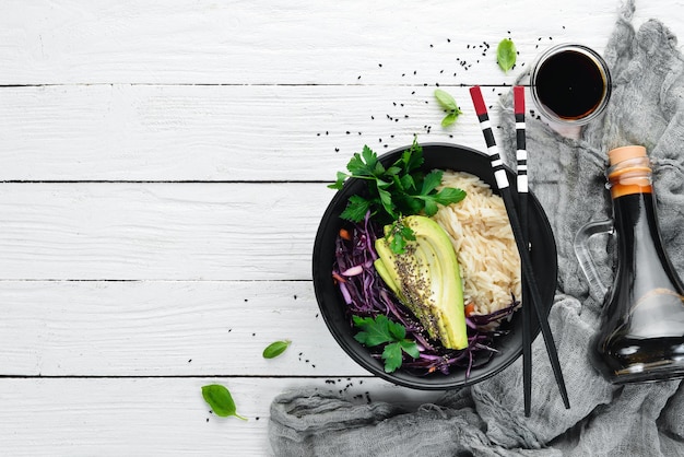 Riso con avocado e cavolo Cibo sano Vista dall'alto Su uno sfondo di legno bianco Spazio libero per la copia