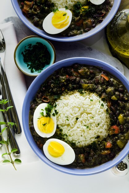 Riso con fagioli neri e uovo sodo sul tavolo con spezie e olio d'oliva