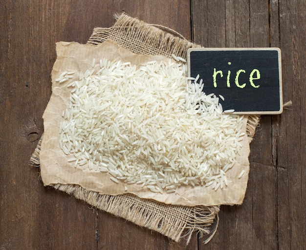 Riso crudo Basmati su legno con una piccola lavagna