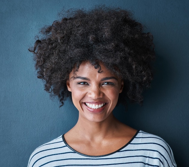 Riso felice e ritratto per donna nera studio e fiducia per sorriso e gioia orgoglio eccitato e faccia con persona isolata per gioia allegra e atteggiamento divertente positivo su sfondo blu