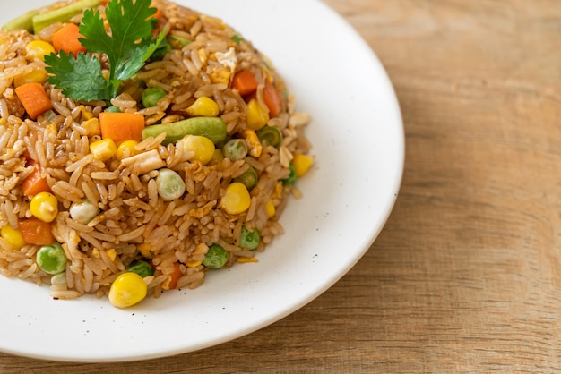 riso fritto con piselli, carote e mais - stile alimentare vegetariano e sano