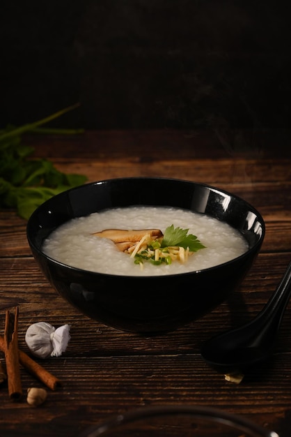 Riso porridge cinese tradizionale in una ciotola con uovo sodo morbido fungo shiitake fetta di zenzero e scalogno fetta Colazione pasto leggero e cibo vegetariano