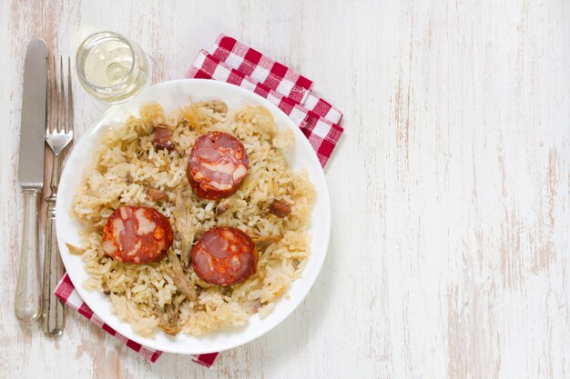 Riso portoghese dell'anatra del piatto sul piatto bianco con vino