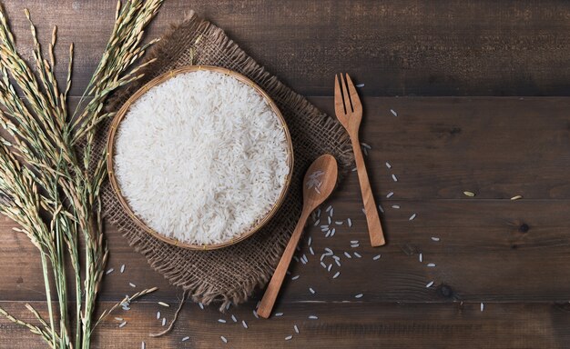 Riso tailandese del gelsomino, riso crudo su fondo di legno