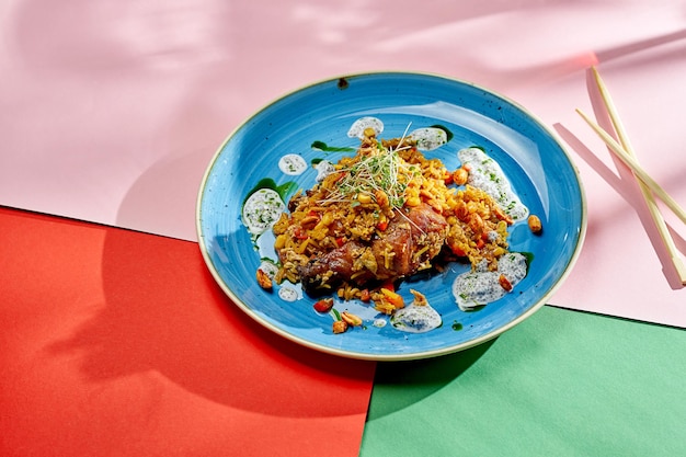 Riso wok asiatico con pollo, arachidi e verdure in un piatto su sfondi luminosi. Messa a fuoco selettiva, luce dura