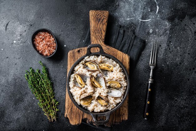 Risotto ai frutti di mare con vongole veraci in padella Backgroud nero Vista dall'alto