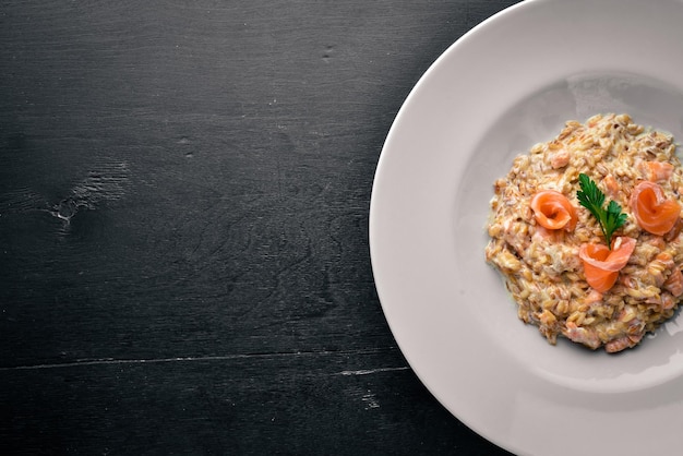 Risotto al salmone e salsa di panna su fondo di legno Vista dall'alto Spazio libero