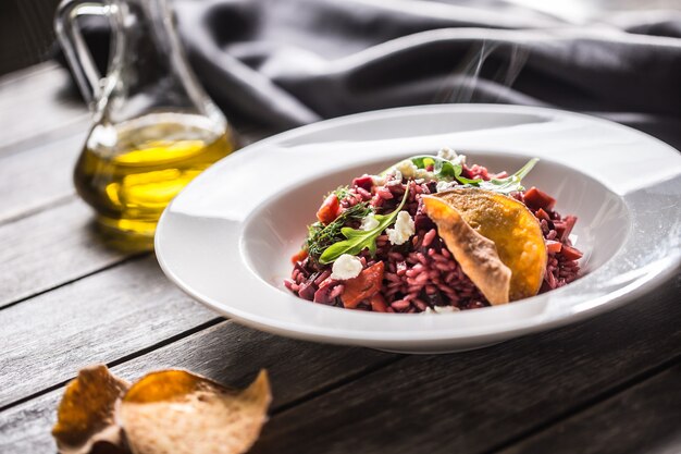 Risotto alla barbabietola con feta chips di patate rucola e olio d'oliva.