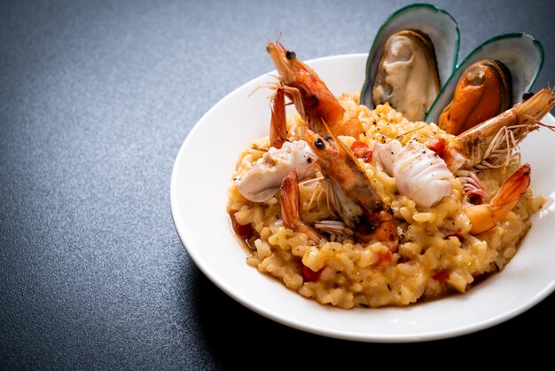 risotto con frutti di mare (gamberi, cozze, polpi, vongole) e pomodori