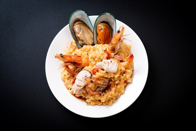 risotto con frutti di mare (gamberi, cozze, polpi, vongole) e pomodori