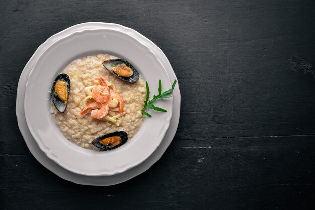 Risotto con gamberi di mare, cozze e calamari e formaggio Su fondo in legno Vista dall'alto Spazio libero