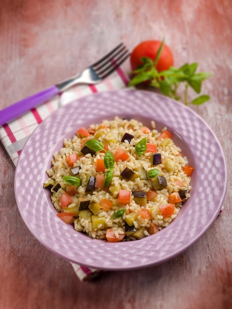 Risotto con melanzane e pomodori freschi a fuoco selettivo