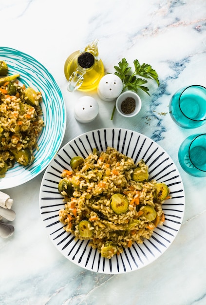 Risotto di primavera su un tavolo di marmo con spezie e olio d'oliva