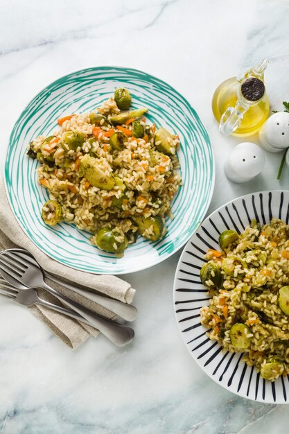 Risotto di primavera su un tavolo di marmo con spezie e olio d'oliva