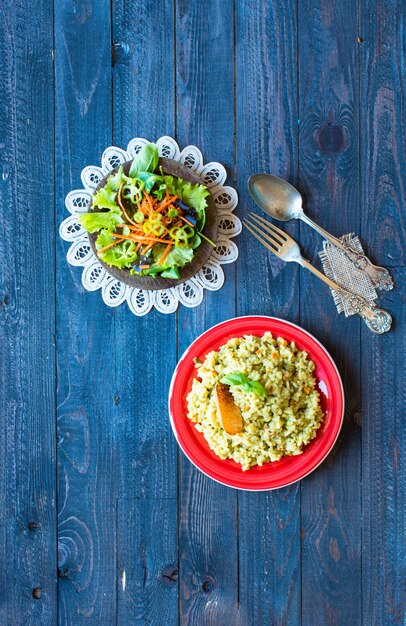 Risotto vegetariano con verdure varie, su tavola rustica in legno,