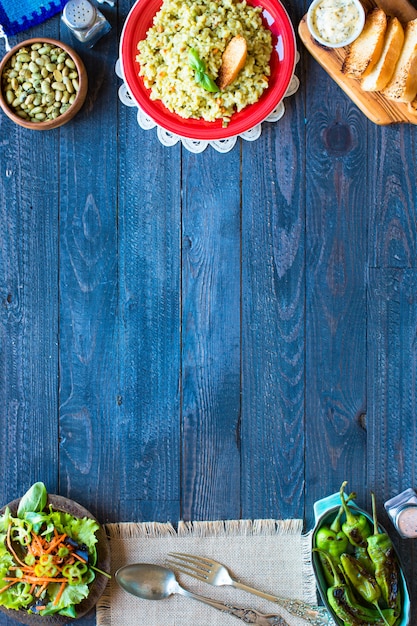 Risotto vegetariano con verdure varie, sul tavolo di legno rustico.