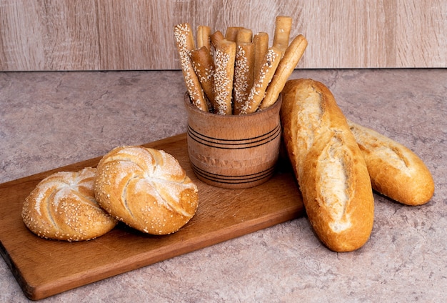 Ð¡risp pane con focacce. Baguette francesi. Pane croccante fresco. Sfondo di pane. Razza diversa su fondo in legno.