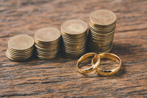 Risparmiare denaro e pianificare il concetto di matrimonio Obiettivo finanziario sostenibile per la vita familiare o coniugale Gli anelli con una pila di monete che risparmiano denaro per sposarsi rappresentano il risparmio o la crescita per la nuova famiglia