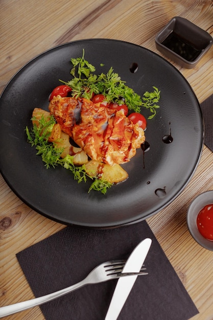 Ristorante di bistecca di pollo con piatto culinario che serve tavolo in legno di stoviglie nere